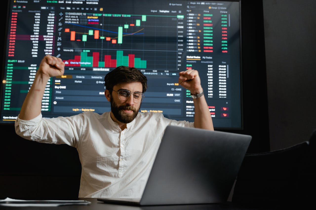 Bearded Man in White Button Up Shirt Sitting in Front of Laptop Feeling Excited